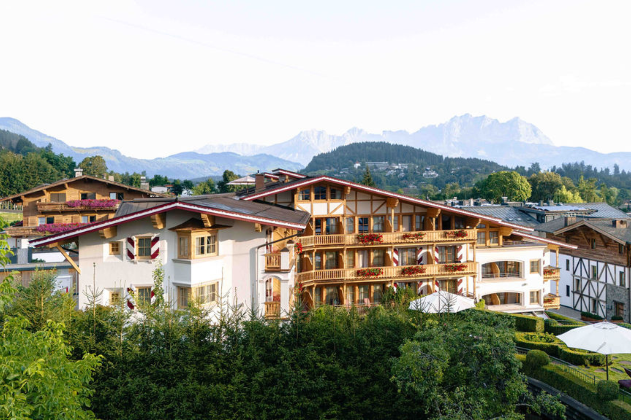 ein Gebäude mit Bäumen und Bergen im Hintergrund